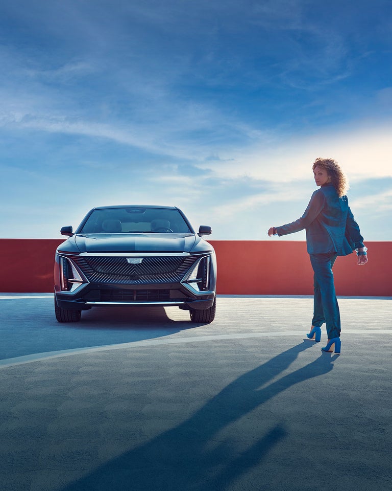 Woman walking toward a parked Cadillac Lyriq