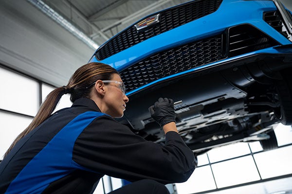 Service Technician working under the front end of a vehicle